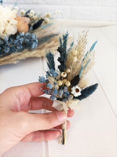 a person is holding some dried flowers in their left hand and the other one has a key on it