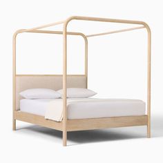 a bed with a wooden frame and white sheets