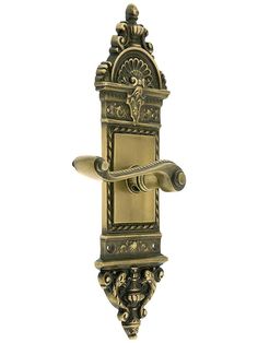 an ornate brass door handle on a white background