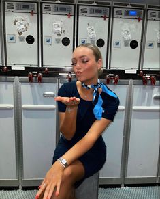 a woman sitting in front of lockers with her finger pointing at the button on them