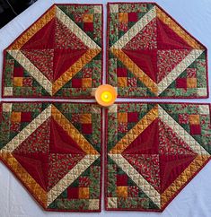 four quilted coasters with a lit candle in the middle