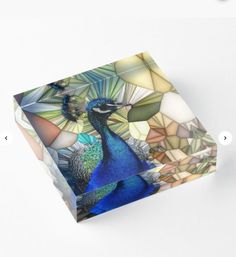 a glass block with a blue bird on it's face and colorful leaves in the background