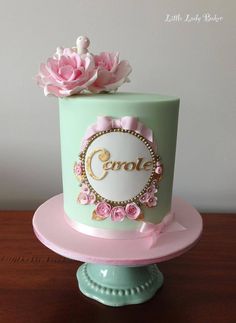 there is a green cake with pink flowers on the top and gold lettering that says genol