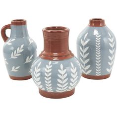 three blue and white vases with leaves painted on the front, one is brown