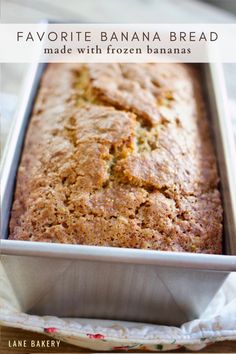 a loaf of banana bread sitting in a pan on top of a wooden table next to a