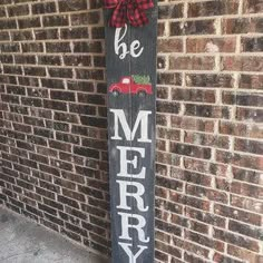 a wooden sign that says be merry with a red plaid bow on it and a truck