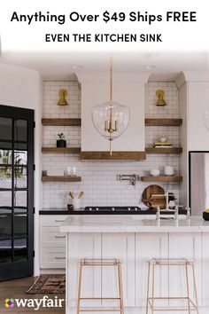 a kitchen with white cabinets and gold accents on the counter tops, along with two bar stools