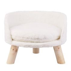 a white chair with wooden legs and a sheepskin seat cushion on top of it