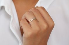 a woman's hand with a diamond ring on her left wrist, wearing a white shirt