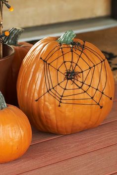 two pumpkins with spider web decorations on them