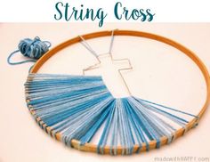 a cross on a wooden hoop with blue thread