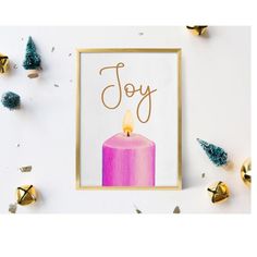 a pink candle with the word joy written on it in gold frame surrounded by christmas decorations