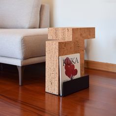 a wooden block sitting on top of a hard wood floor next to a chair and couch