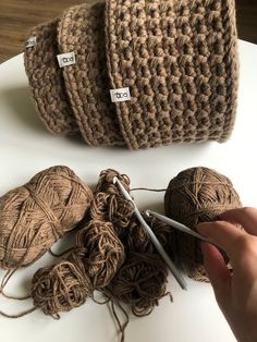 someone is crocheting balls of yarn on a table