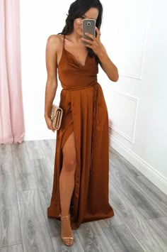 a woman in a brown dress taking a selfie