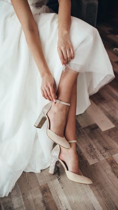 the bride is tying her wedding shoes