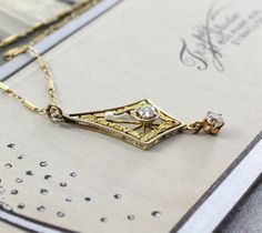 "Circa 1915, an elegant Edwardian lavaliere crafted in 14k yellow and white gold. The delicacy of the design is a perfect counterpoint to the blazing bright old mine-cut diamond set in the center, approximately .15 ct., accented by a single creamy pearl and finished with a fiery old mine-cut diamond drop, approximately .18 ct. It would be a wonderful piece for the bride who wants a romantic antique vibe; combining the gemlore of pearls and their symbolic reference to faithfulness and purity of h Gold Filigree, Diamond Drops, Philadelphia Pa, Bridal Necklace, Necklace Jewelry, The Bride, Arrow Necklace, Diamond Cuts, Jewelry Necklaces