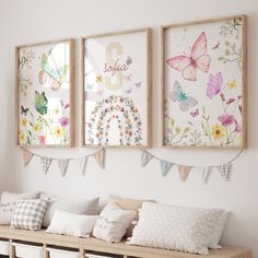 three framed pictures hang on the wall above a bench with pillows and pillowcases