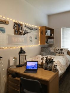 a room with a bed, desk and laptop computer on the table in front of it