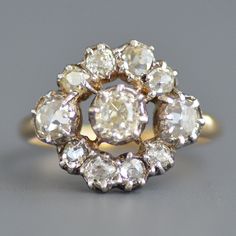 A fabulous antique Georgian period (1714-1837) old mine cut diamond ring in sterling silver & 14k yellow gold. This beautiful antique diamond ring features a sterling silver face with a gold back, as was typical of this period, with all antique romantic sparkling old mine cut diamonds cut down collet set in a wonderful circular pattern with the largest and warmest in the center flanked with medium sized diamonds on the sides and smaller diamonds on the top and bottom leading to a smooth simple g Antique Cluster Ring With Rose Cut Diamonds, Antique Brilliant Cut Diamond White Ring, Antique Brilliant Cut Diamond White Diamond Ring, Antique Diamond White Diamond Ring With Brilliant Cut, Antique Diamond Ring With Center Stone, Antique Diamond White Diamond Ring, Victorian Diamond White Ring With 17 Jewels, Victorian Cluster Ring With Brilliant Cut In Diamond White, Antique Diamond White Ring With Center Stone