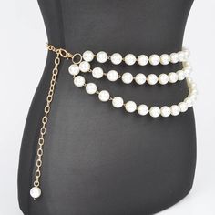 A sophisticated blend of elegance and style, the Multi Layered Pearl Gold Chain Belt is a statement accessory for any fashion-forward wardrobe. This exquisite piece features multiple layers of lustrous pearls intertwined with gleaming gold chains, creating a stunning contrast that catches the eye. Whether you're dressing up for a special occasion or adding a touch of glamour to your everyday outfit, this belt is sure to make a lasting impression. - 0.65" Wide x 47" Long - Imported Elegant Double Chain Belt For Evening, Pearl Multi-strand Necklace For Parties, White Double Chain Jewelry For Party, Gold-tone Chain Belt For Party, Elegant Chain Necklace With Chain Strap As Gift, Chic Beaded Chain Jewelry For Evening, Party Metal Chain Necklace With Pearl Chain, Elegant Beaded Waist Chain As A Gift, Chic Evening Jewelry With Beaded Chain