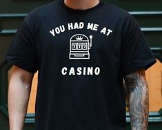 You had Me at Casino Shirt funny Casino Shirt Funny Casino Shirt Gambling T Shirt Slot Machine Shirt Casino Gift Funny Gambling Shirt Thank you for considering purchasing from Raven Printing Company.  We are based out of Cleveland, Ohio and would love to have the opportunity to earn your business. Because we are a small business we cannot accept returns or exchanges.  However if your product does not meet your standards please reach out and we would be more than happy to work with you on a solut Novelty Black Tops With Funny Text, Black Novelty Crew Neck Shirt, Black Crew Neck Novelty Shirt, Novelty Crew Neck Shirt With Screen Print, Novelty Crew Neck Pre-shrunk Shirt, Funny Text Crew Neck Shirt, Novelty Crew Neck Top With Funny Text, Novelty Graphic Print Shirt With Crew Neck, Black Novelty Tops With Slogan