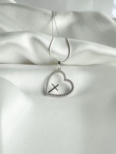 Showcase your faith with the Chrissie Silver Necklace. Made of sterling silver, this elegant piece features a delicate cross nestled within a heart, symbolizing your devotion. Perfect for any occasion, it's a timeless reminder of your beliefs. Product Details Materials: 925 Sterling Silver, Cubic Zirconia Size: Necklace 20 inches, Heart 20mm Stacked Earrings, Anklet Bracelet, Watch Necklace, Bracelet Stack, Earring Necklace, A Heart, Sterling Silver Necklaces, Watch Bands, Anklets