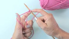 two hands holding yarn and knitting needles over a ball of yarn with another hand in the background