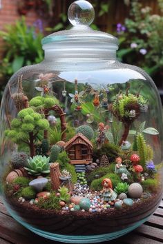 a glass jar filled with lots of different types of plants and animals on top of a wooden table