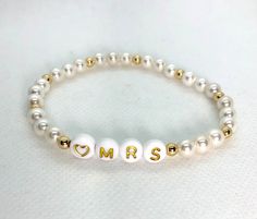 "This listing is for ONE custom heishi bead bracelet.  (See bridal stack listing if you're wanting all three: https://etsy.me/3b200dN) Use drop down to select pearl or colors. You'll use the personalization box to let me know if you're choosing the Mrs. or the Bride. NOTE If you're ordering more than 1 you'll need to add each bracelet to the cart separately with notes for that particular bracelet. (Message me if you're wanting some \"bride tribe\" bracelets to go with it.) These are stretch brac Bride Tribe Bracelet, Bridal Stack, Letter Bead Bracelet, Heishi Bead Bracelet, Bracelets Stack, Bracelet Message, Letter Bead Bracelets, Bride Bracelet, Perfect Gift For Girlfriend