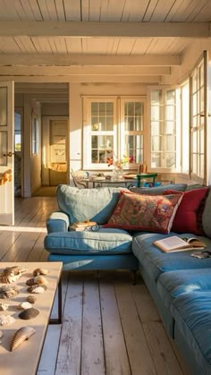 a blue couch sitting on top of a wooden floor in a living room next to a table