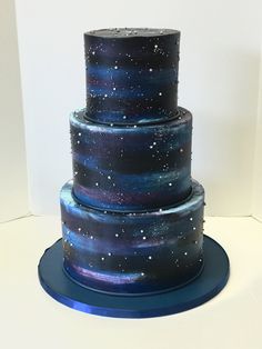 a three tiered cake with stars painted on it