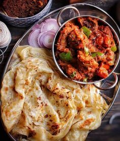 some food that is on a plate and next to other foods, including breads