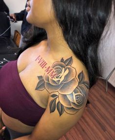 a woman with a rose tattoo on her chest and name tattooed on the back of her shoulder