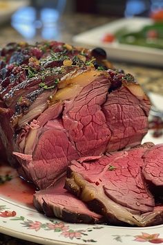 a piece of roast beef on a plate with cranberry sauce and garnishes