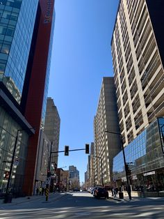 an empty city street with tall buildings on both sides and traffic lights in the foreground