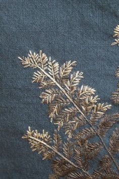 some very pretty plants with gold leaves on blue fabric, close - up view from the bottom