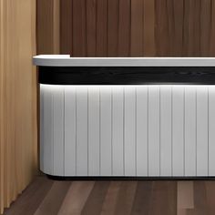 a white and black cooler sitting on top of a wooden floor next to a wall