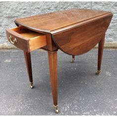 a wooden desk with one drawer open on the top and two drawers closed at the bottom