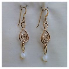 This pair of earrings is made from 14/20 gold filled wire.  The wire is shaped and formed and attached with 14/20 gold filled jump rings.  The opal Swarovski crystal beads are then attached to the earrings. The ear wires are also 14/20 gold filled. The length on these earrings is approximately 2 1/8". Gold Wire-wrapped Crystal Earrings, Gold Wire Wrapped Crystal Earrings In Brass, Gold Wire Wrapped Sterling Silver Crystal Earrings, Gold Wire Wrapped Crystal Earrings, Gold Wire Wrapped Crystal Earrings As Gift, Adjustable Gold Wire Wrapped Crystal Earrings, Gold Wire Wrapped Adjustable Crystal Earrings, Gold Wire Jewelry With Matching Earrings, Gold Wire Wrapped Dangle Crystal Earrings