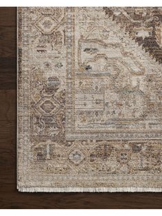 an area rug with brown, beige and tan colors on top of a wooden floor