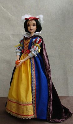 a doll dressed as snow white holding an orange