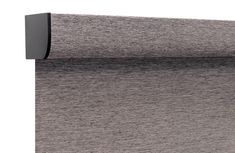 a close up view of the side of a roller blind with grey fabric on it