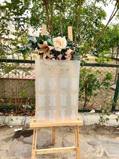 a sign with flowers on it in front of a fence