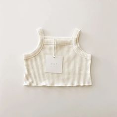 This beautiful summertime crop tank is one of our favorite pieces for summer. Paired with the matching ribbed shorts this dreamy vintage stripe pattern set is the perfect capsule outfit. The shape, the soft ribbed cotton, the color, everything about this tank is something to love. Ethically made Made of: 95% Premium Ribbed Cotton, 5% Spandex Care: Wash Cold, Gentle Cycle, Dry Flat Summer Beige Ribbed Crop Top, Summer Ribbed Beige Crop Top, Summer Striped Ribbed Tops, Striped Ribbed Cotton Tank Top, Cute Ribbed Cotton Tops, White Summer Crop Top For Loungewear, Beige Tops For Summer Playwear, Playful Everyday Summer Tops, Beige Cotton Tops For Playwear