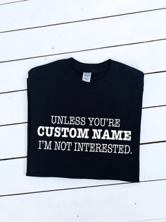 If you're not Custom name I'm not interested slogan printed T-shirt A super soft T-shirt with a central graphic. A perfectly versatile item offering style and comfort.   Several colour t-shirts available: White (black print). Black. Forest Green. Navy. Yellow. Pink. Garment info: Manufactured  from  100% Cotton with taped neck and shoulders. Fit is relaxed casual, though for the baggier look we suggest buying the next size up.  Print on black T-shirt is white. If you would like a different colou Funny Crew Neck Top With Name Print, Funny Black T-shirt With Name Print, Funny Cotton Tops With Custom Text, Funny Short Sleeve Tops With Custom Text, Funny Black Tops With Custom Text, Funny Crew Neck T-shirt With Custom Print, Funny Custom Print Crew Neck T-shirt, Black Print, Look Plus