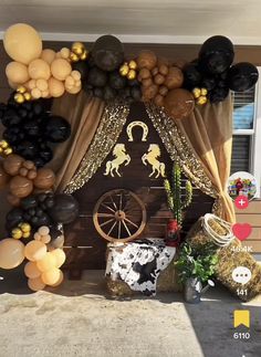 an outdoor display with balloons and decorations on the outside wall, including a horse stable