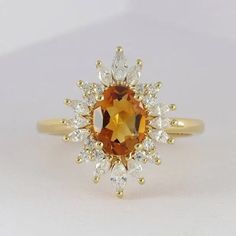 an orange and white diamond ring sitting on top of a table