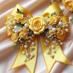 a yellow ribbon with flowers and pearls on it