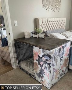 a bed with a white headboard and floral print blanket on it next to a dog cage